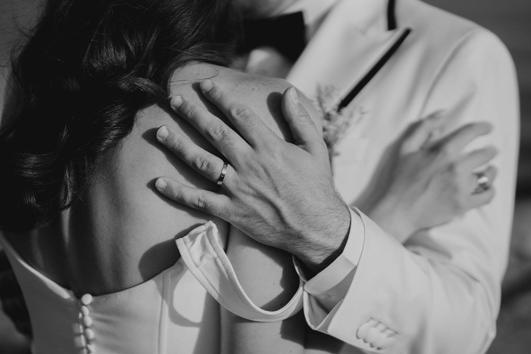 Le mani dello sposo sulla schiena della sposa